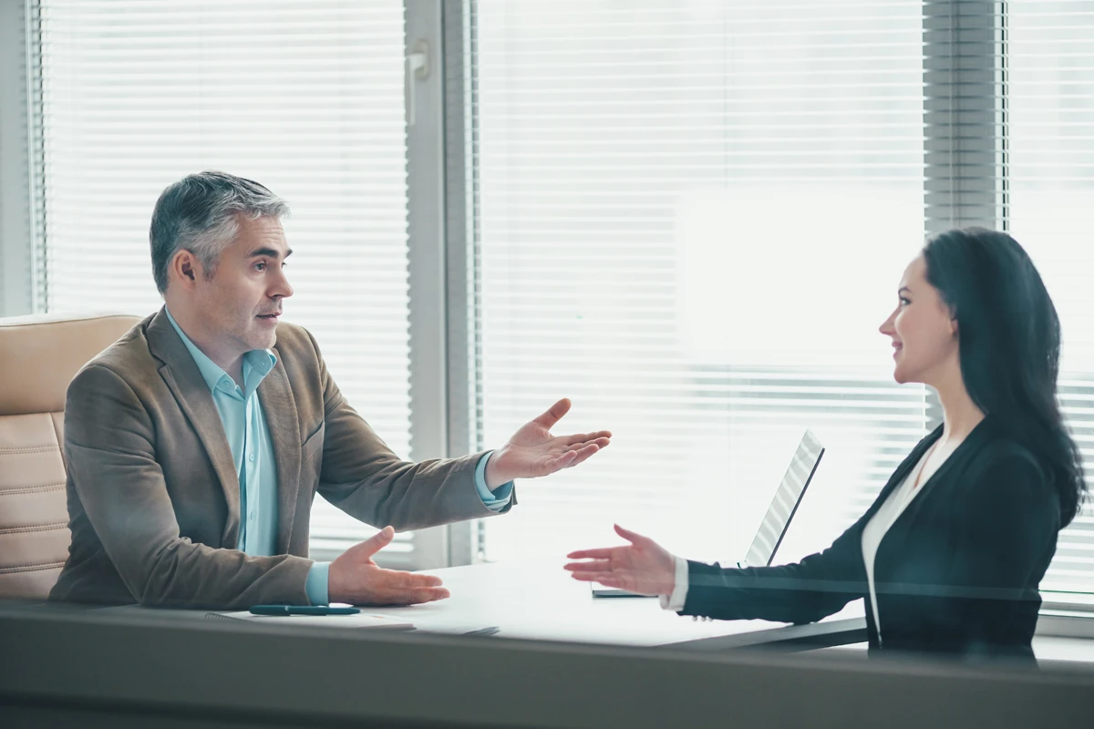 A couple reviews life insurance options with an advisor while comparing policy tradeoffs