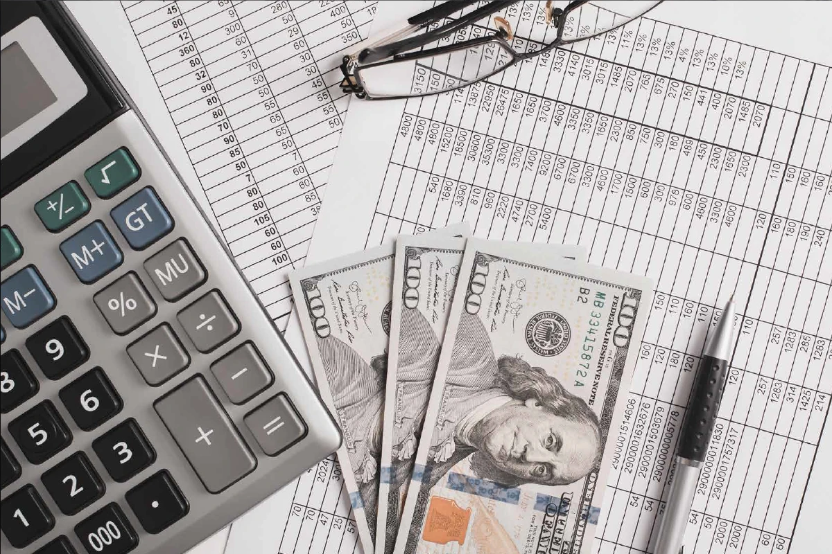 Person reviewing financial statements and budget with calculator