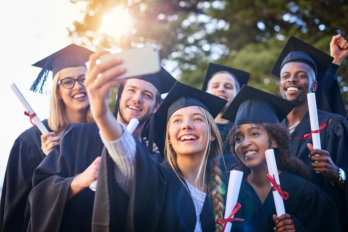 a group of people in graduation gowns and caps taking a selfie