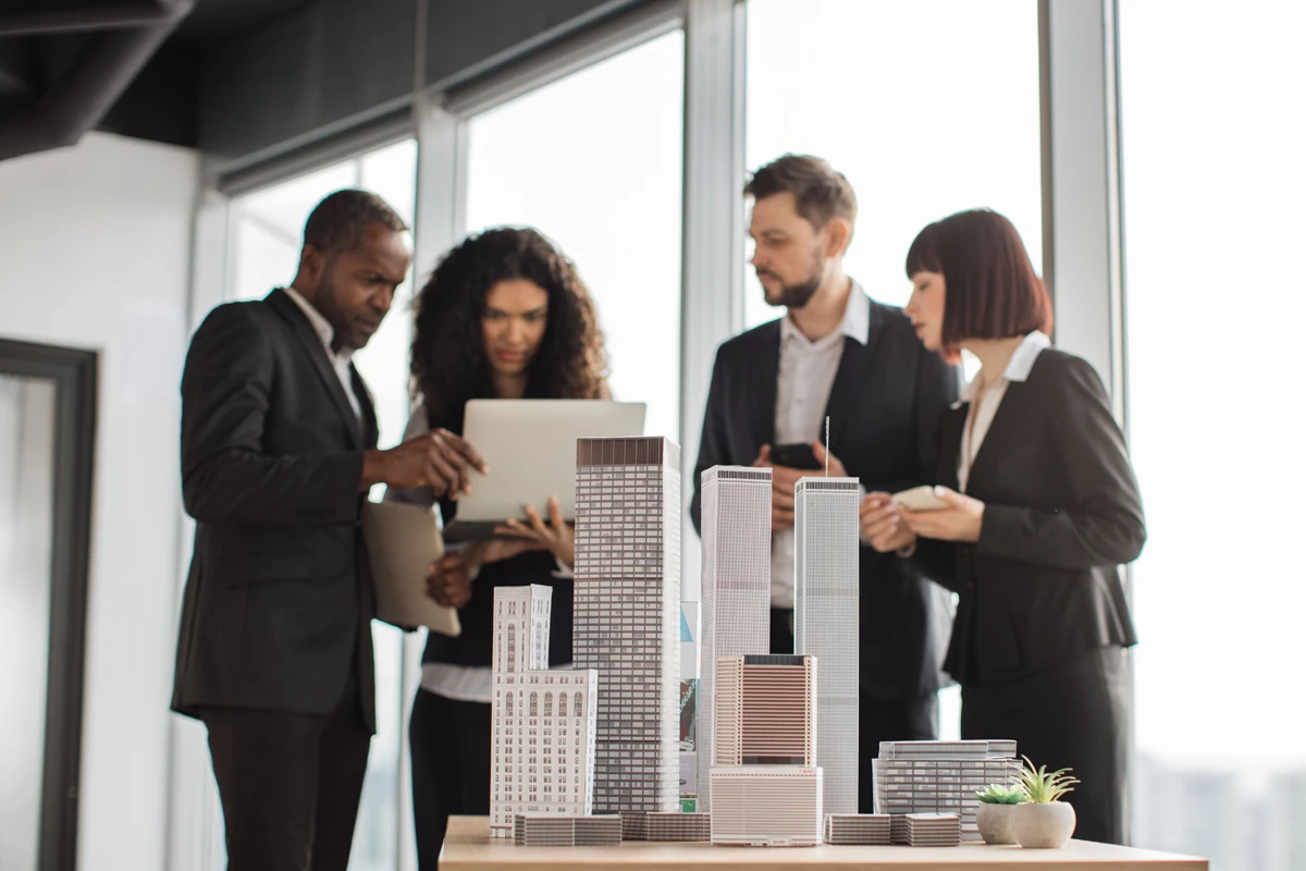 Architects discussing over models in modern office