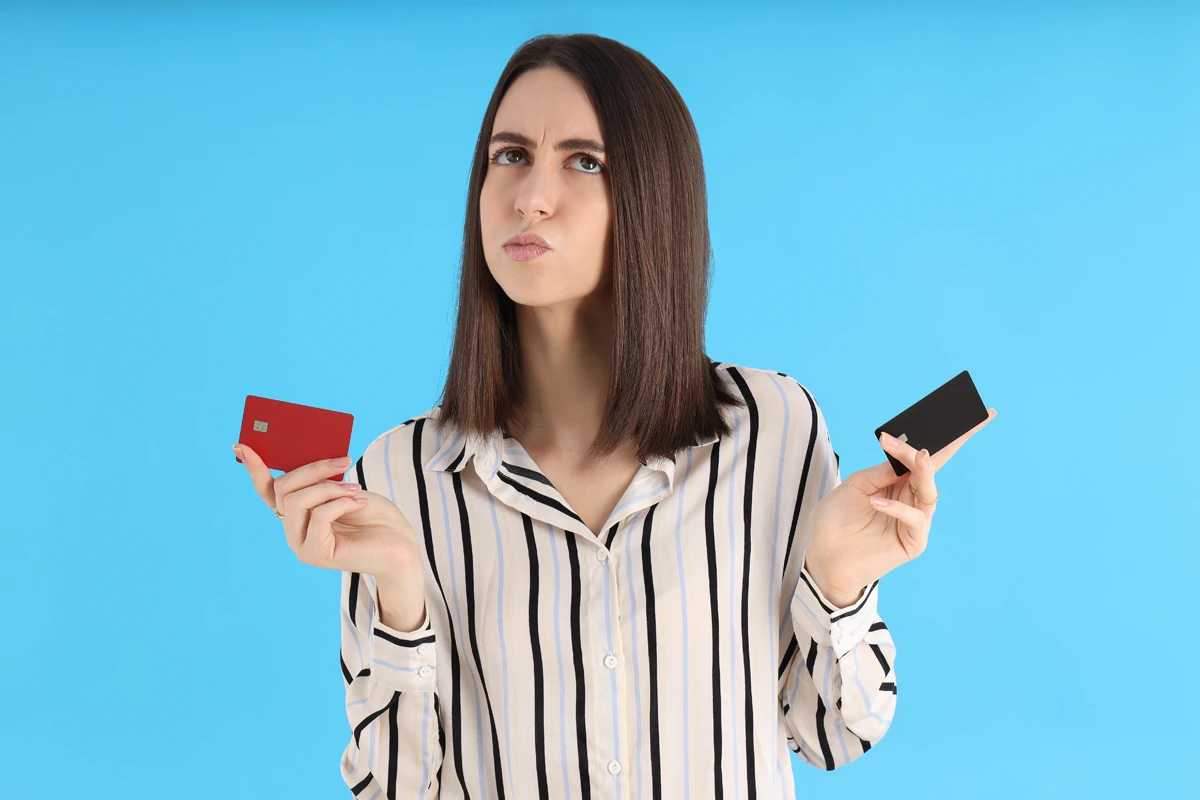 Woman choosing between credit cards.
