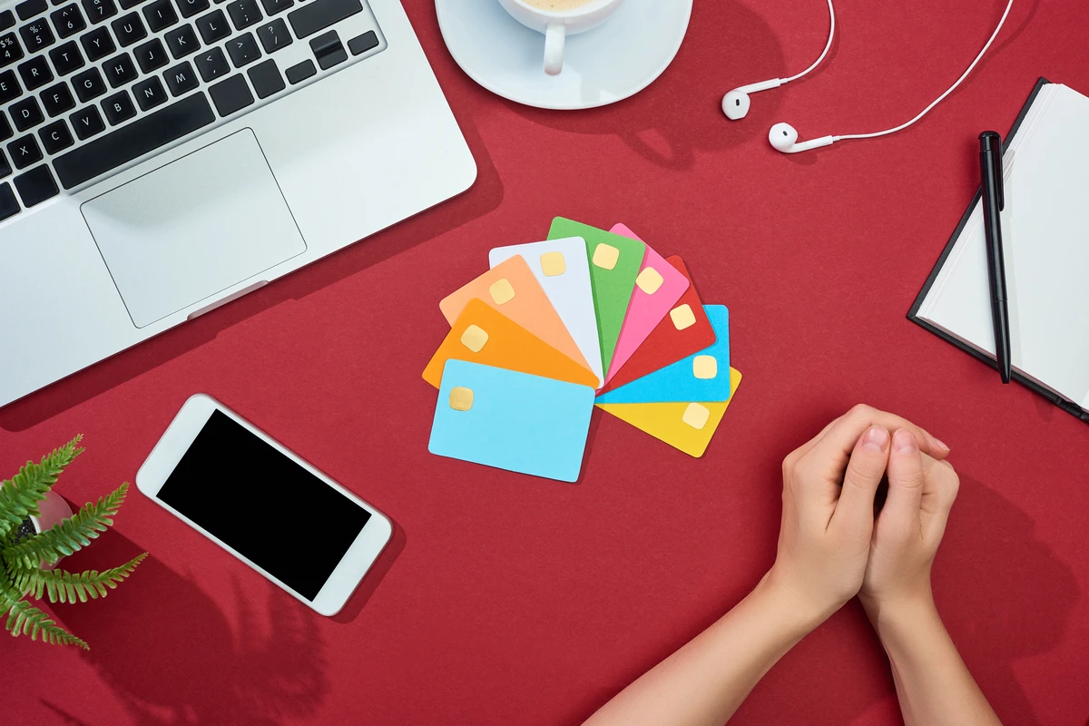 A person surrounded by credit cards and debt paperwork