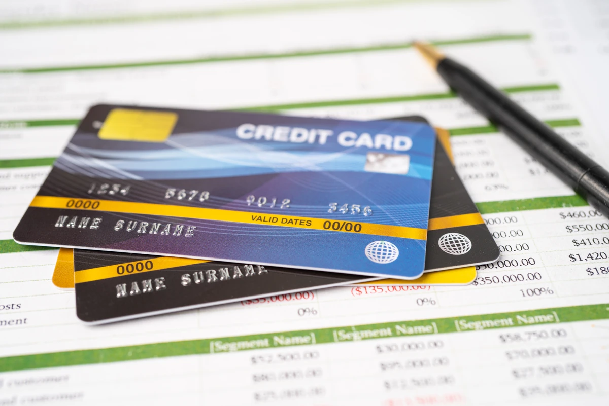 Credit cards on financial documents with pen.