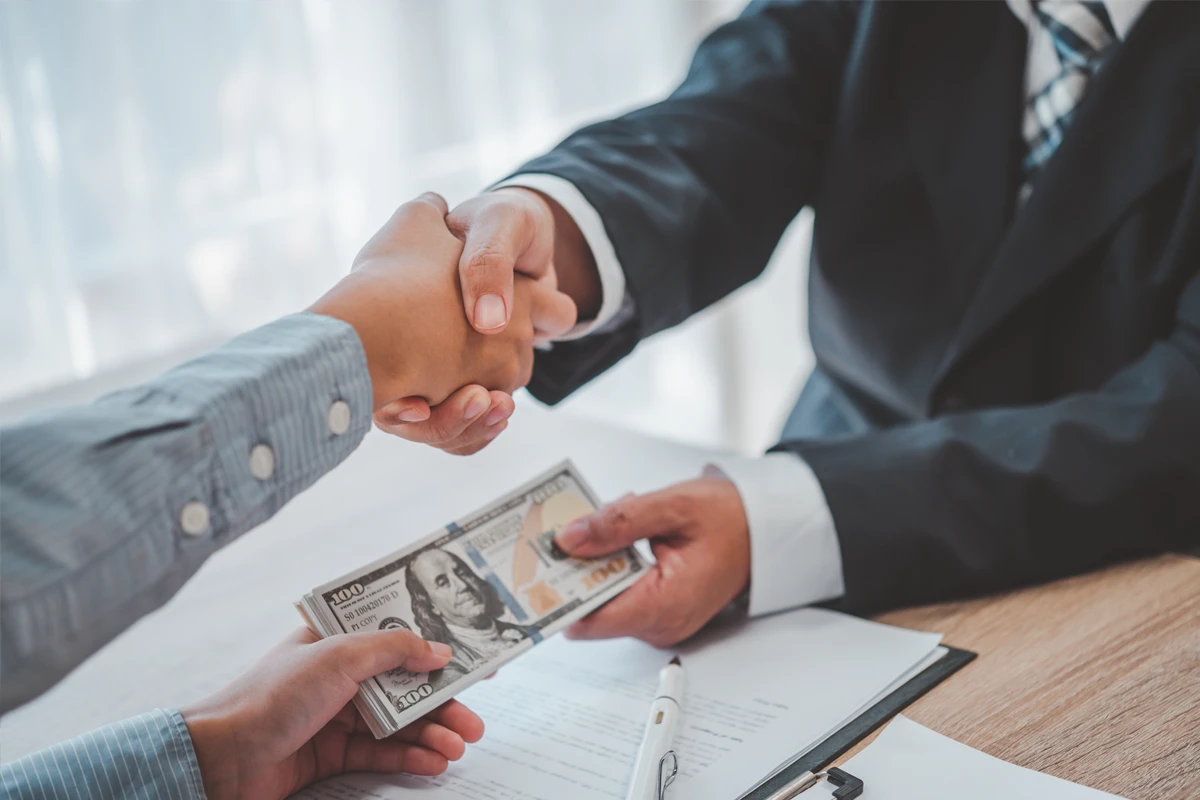 Handshake with money exchange, business corruption concept