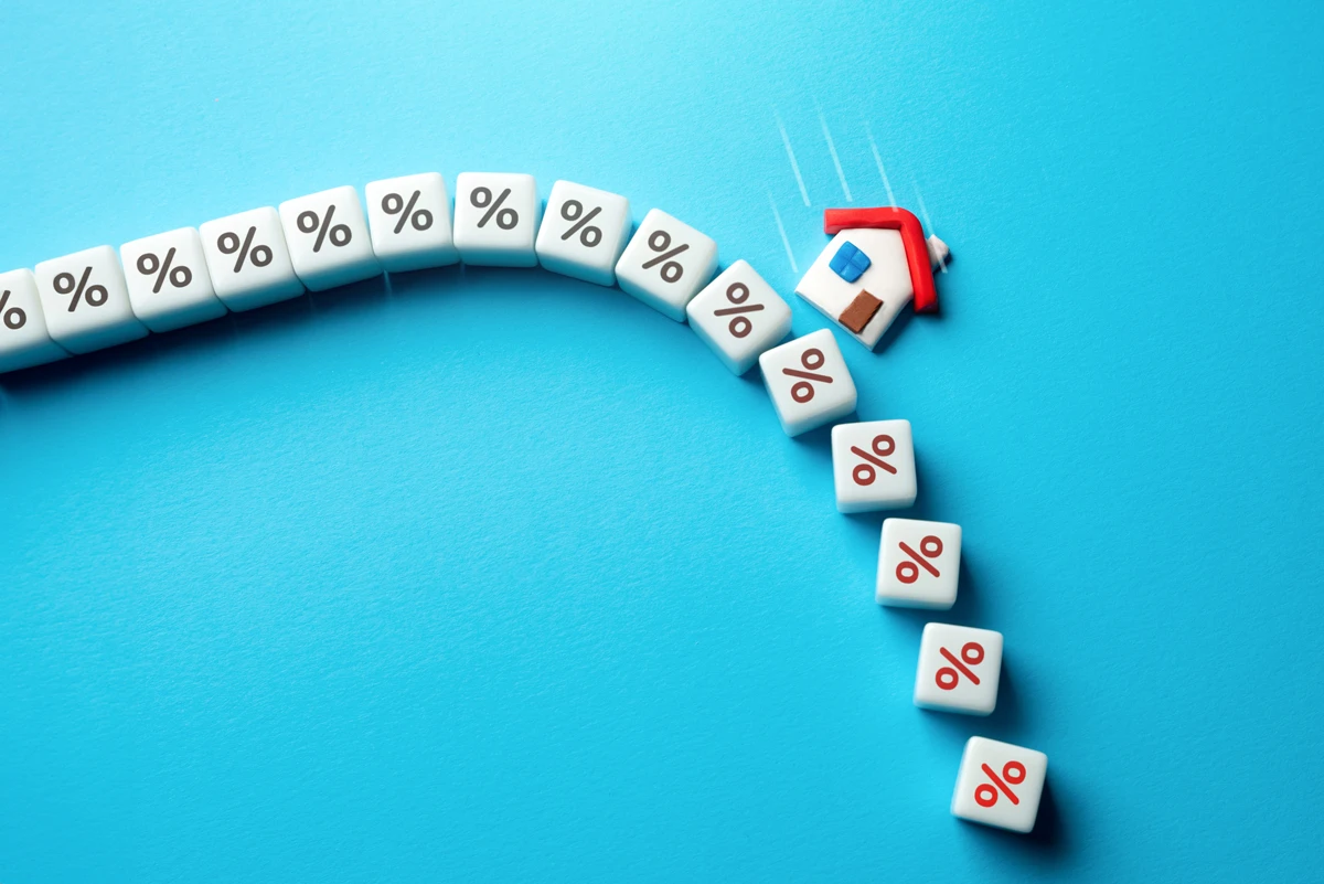 Falling house with percentage sign domino effect.