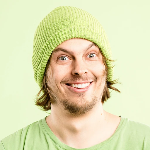 Man in green hat and shirt smiling mischievously