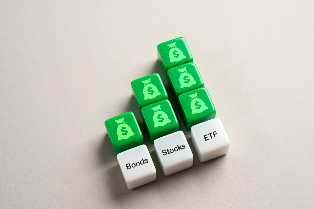Dice labeled Bonds, Stocks, ETFs with dollar symbols
