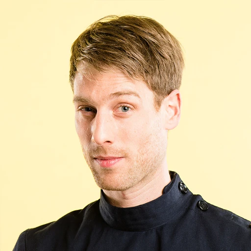 Man with subtle smile against yellow background