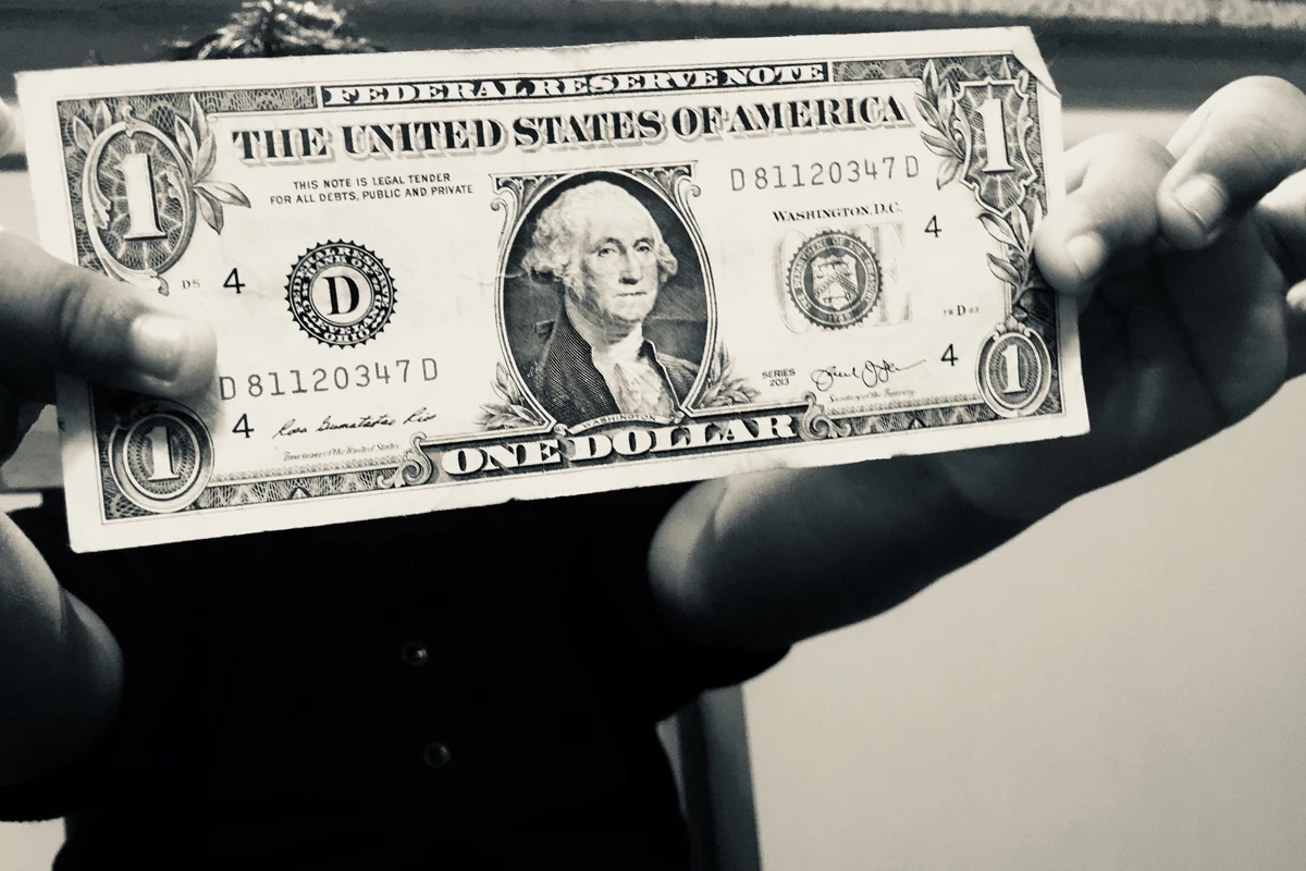 Person holding a one dollar bill