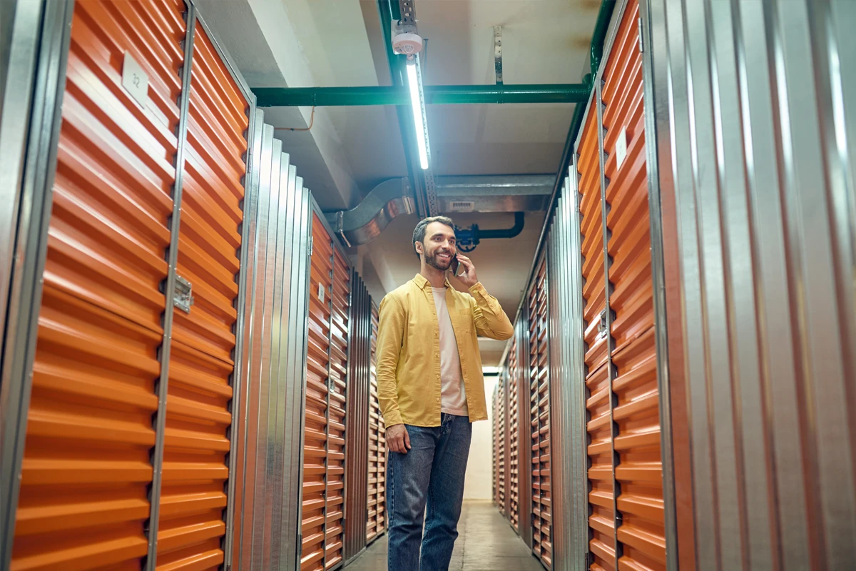 Man talking on phone in storage facility corridor