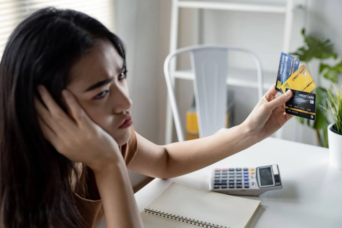 Worried woman holding multiple credit cards