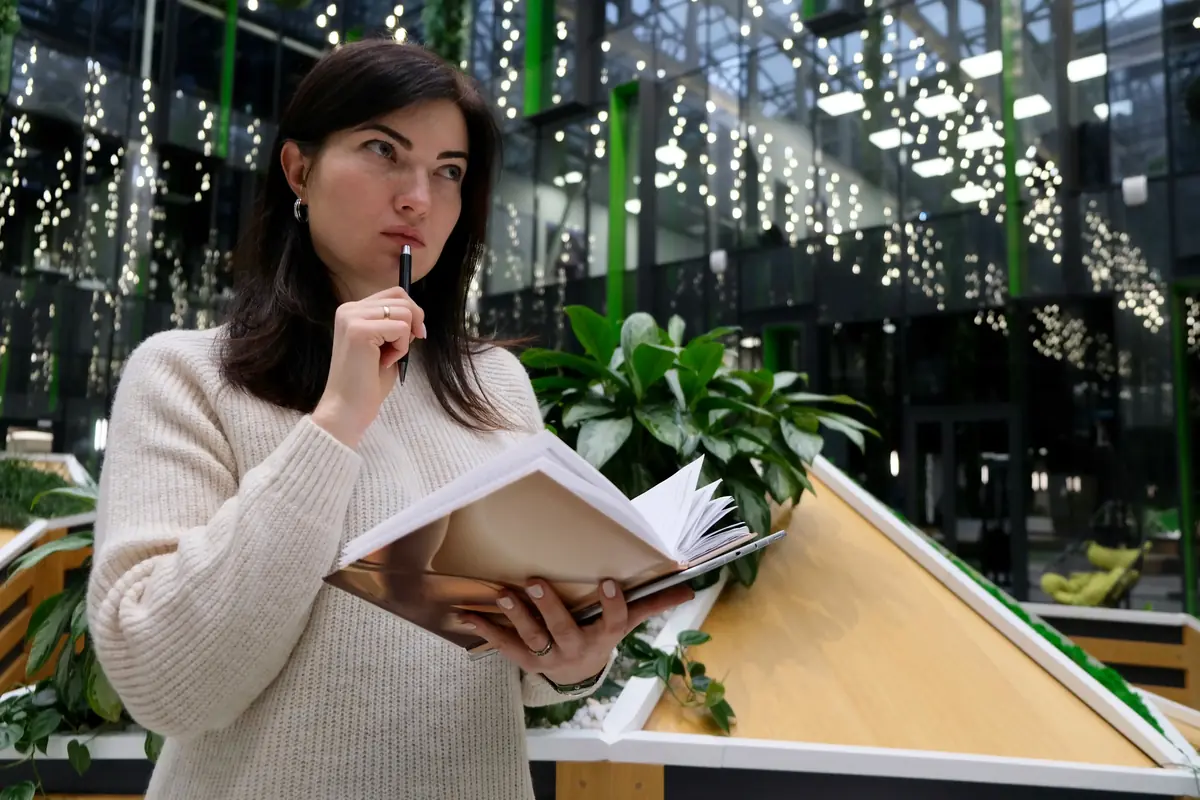 A woman thinking through a plan with notebook and pen, reflecting the care needed when choosing an executor.
