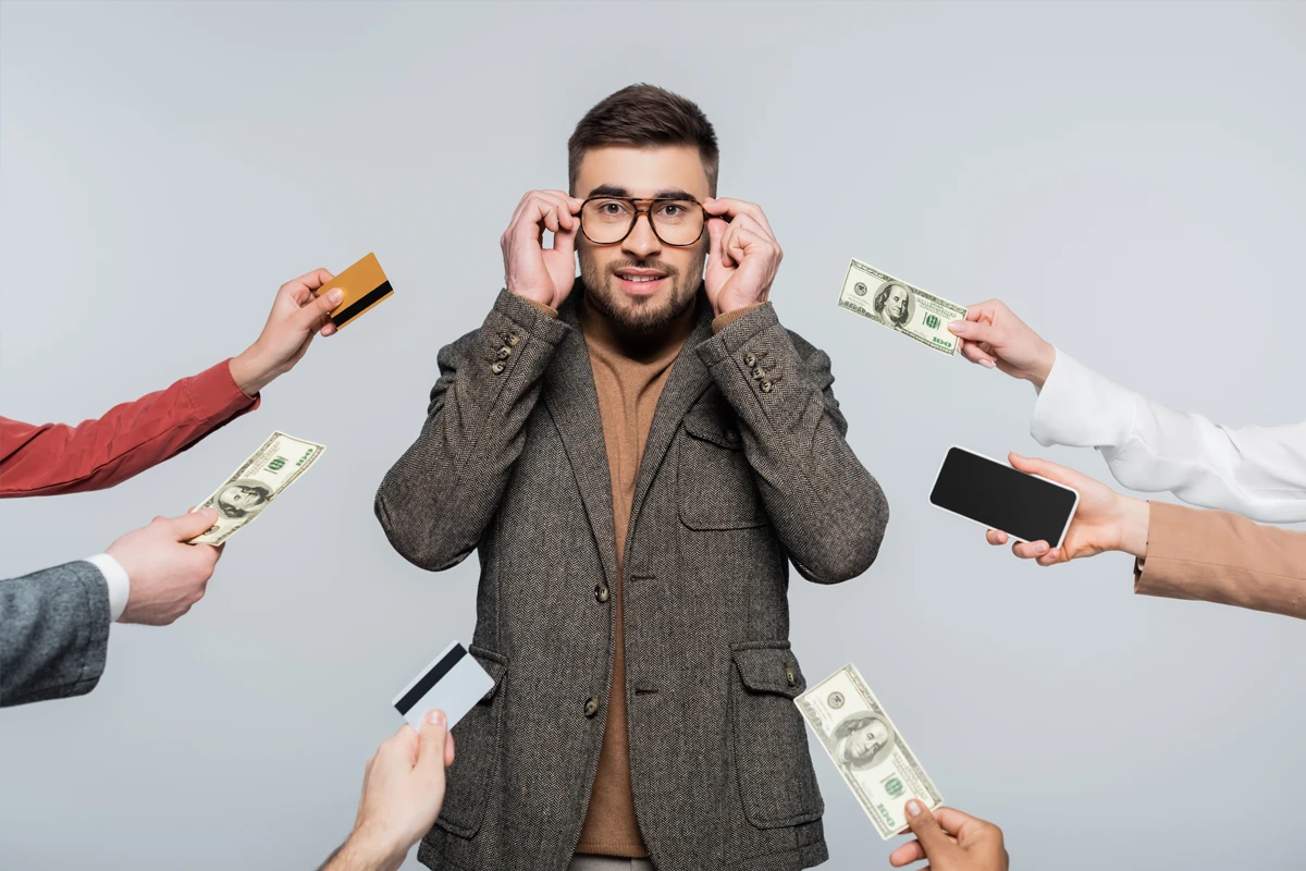 Man surrounded by money, cards, and phone offers.