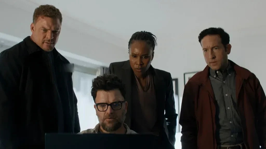 Reacher and three other people examine a computer screen.