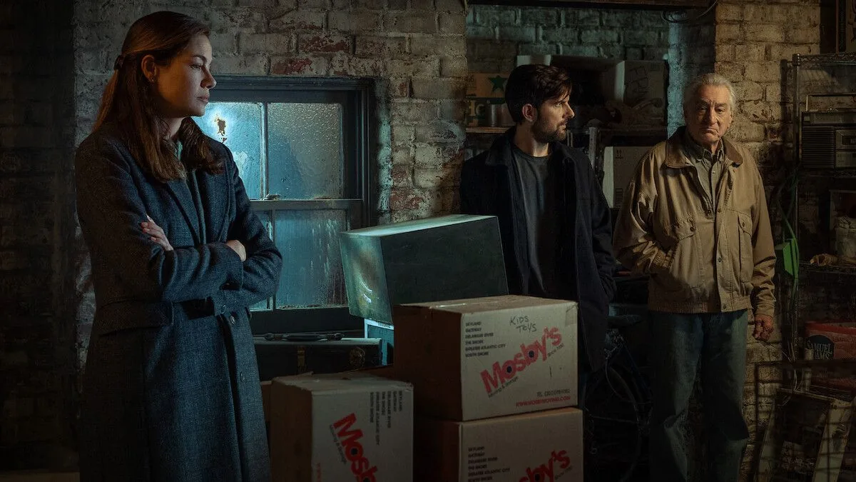 Adam Scott, Michelle Monaghan og Robert De Niro står i et dunkelt rum i The Whisper Man