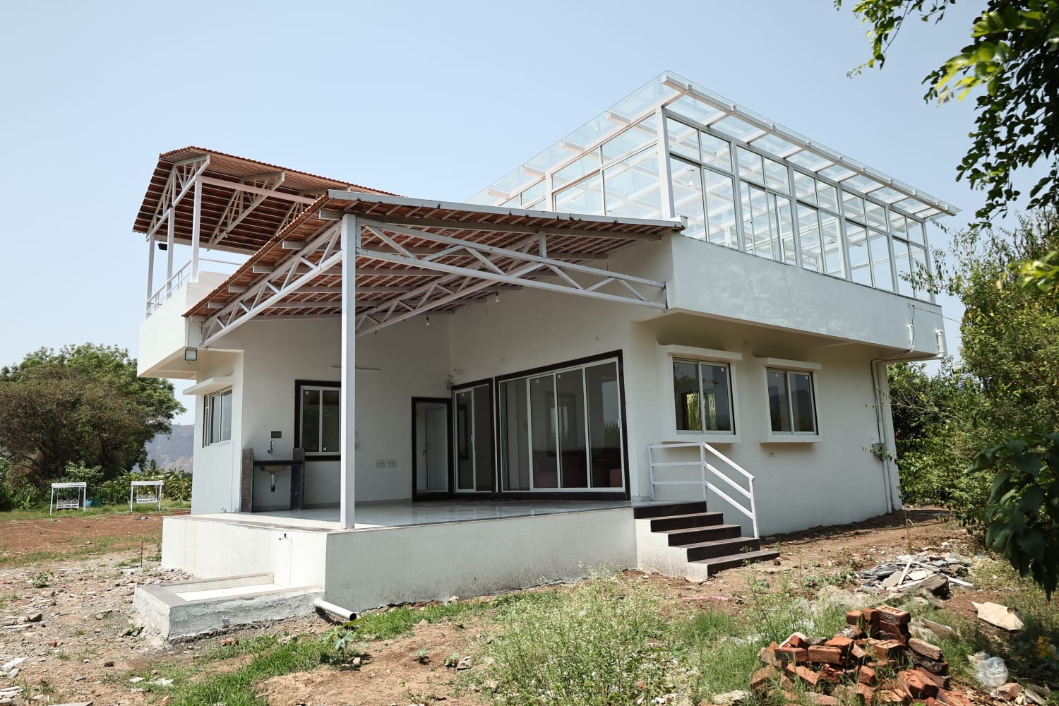 Modern luxury farmhouse exterior at Aramzone Villa with rooftop glass lounge