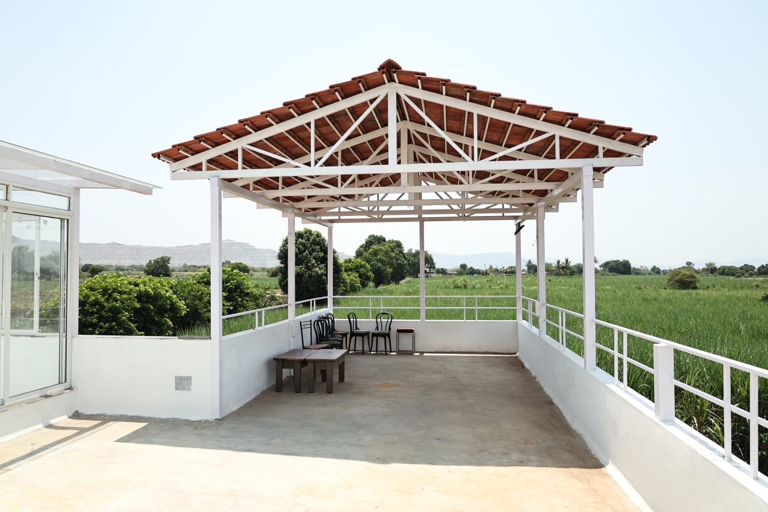 Open rooftop seating area at Aramzone Villa with scenic green countryside views