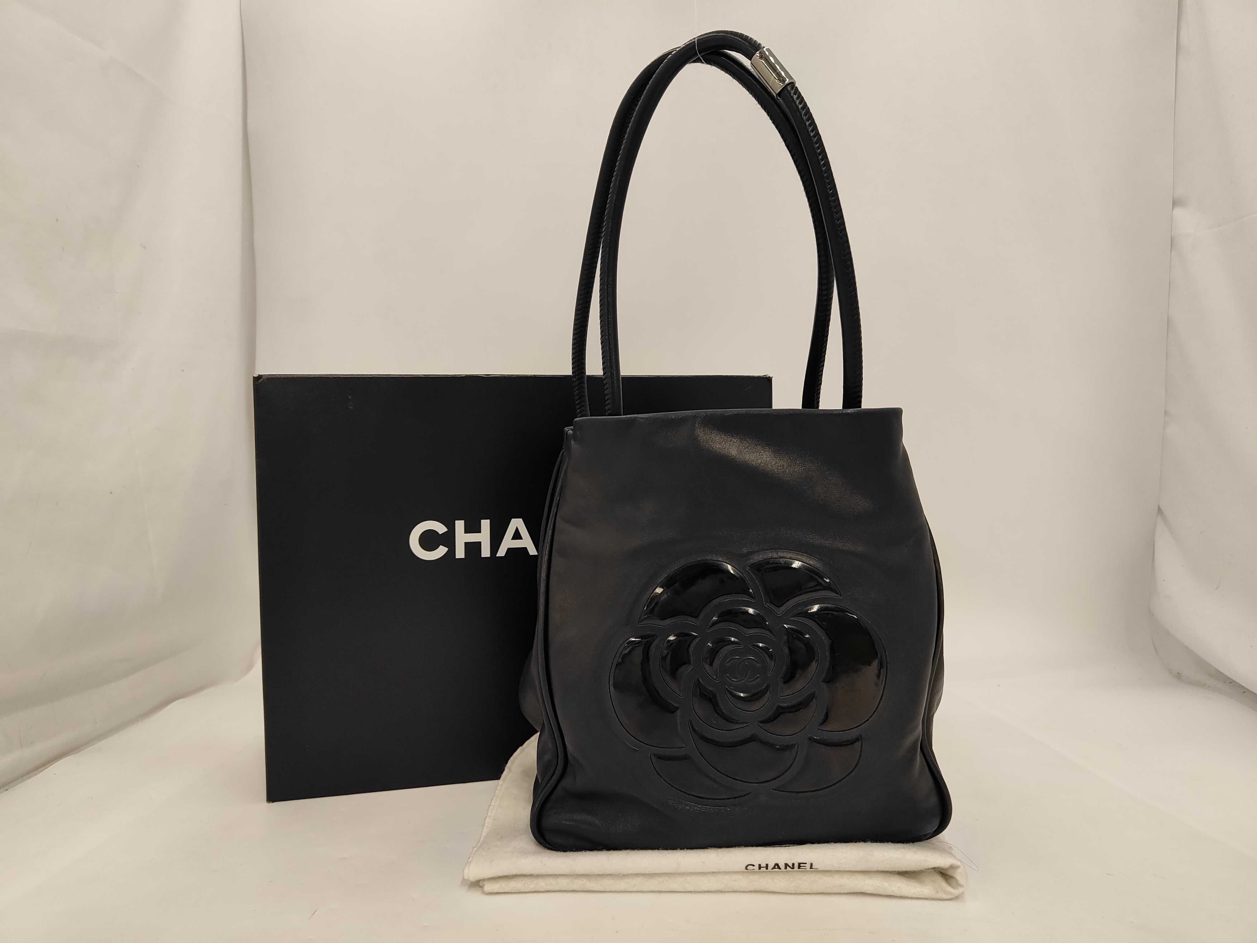 leather tote bag with black camellia logo sticker.