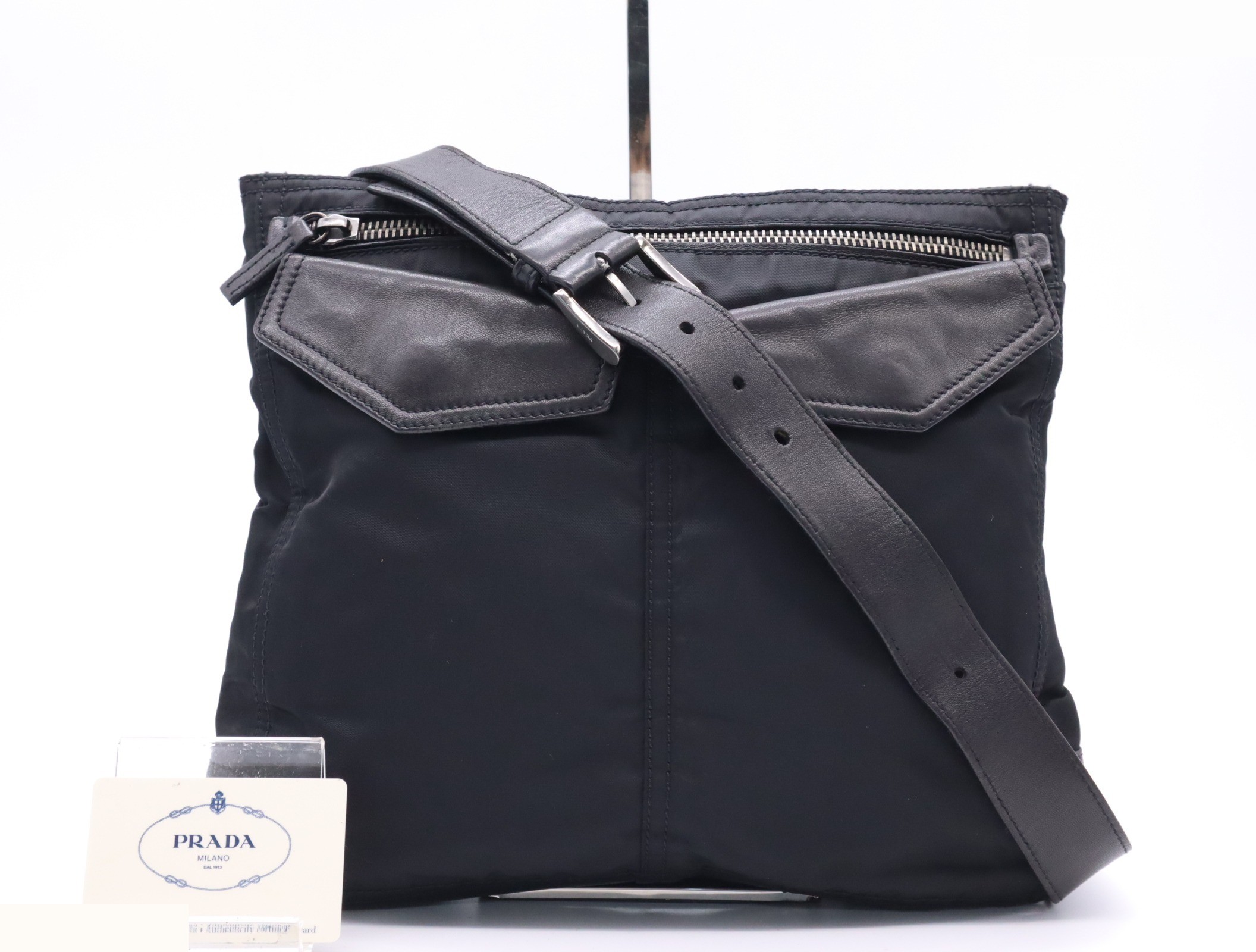 Nylon shoulder bag with triangular logo, black, silver hardware, and card included.