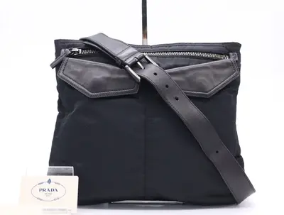 Nylon shoulder bag with triangular logo, black, silver hardware, and card included.