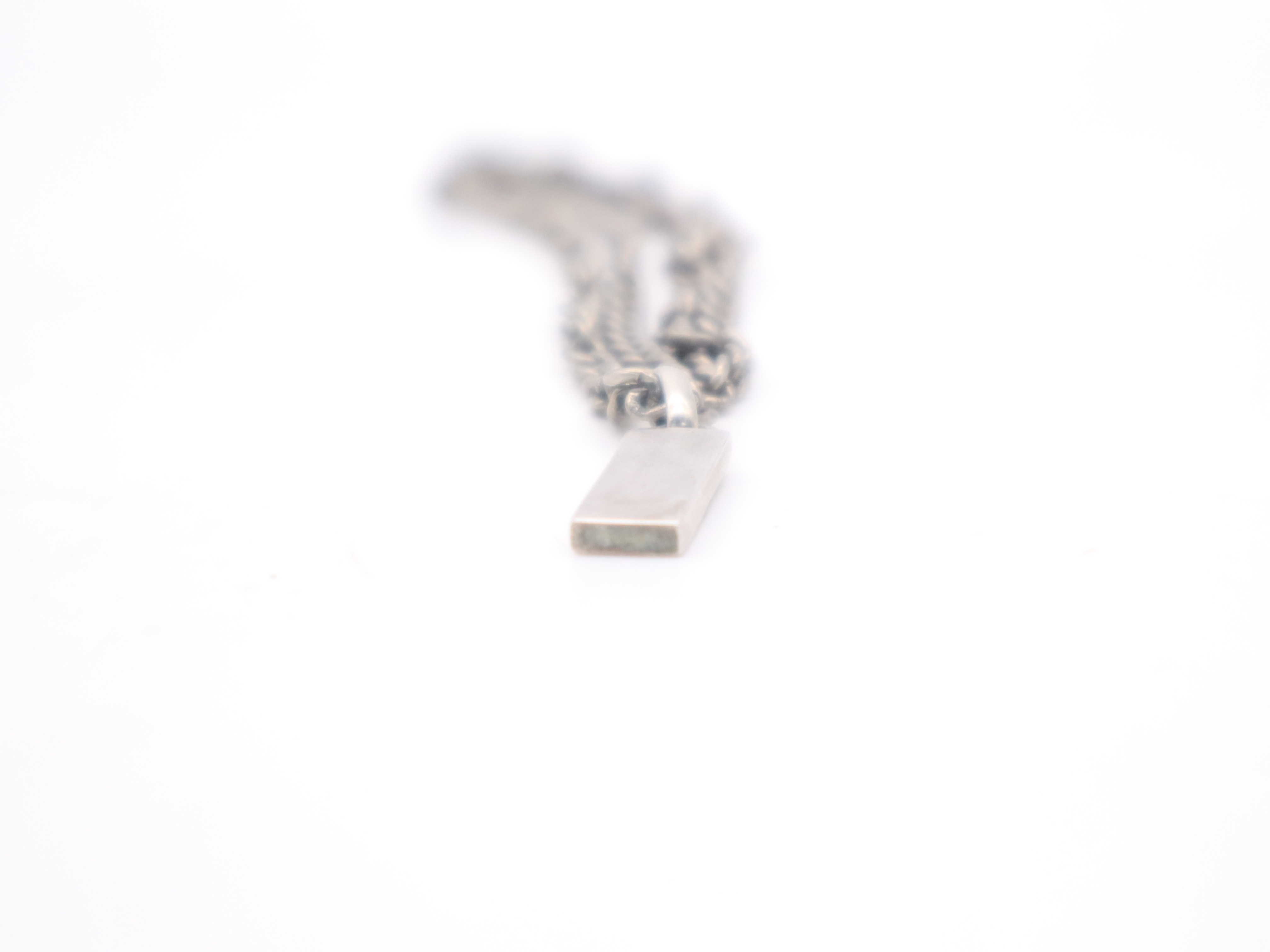 necklace with silver logo plate, box, and dust bag. — view 4