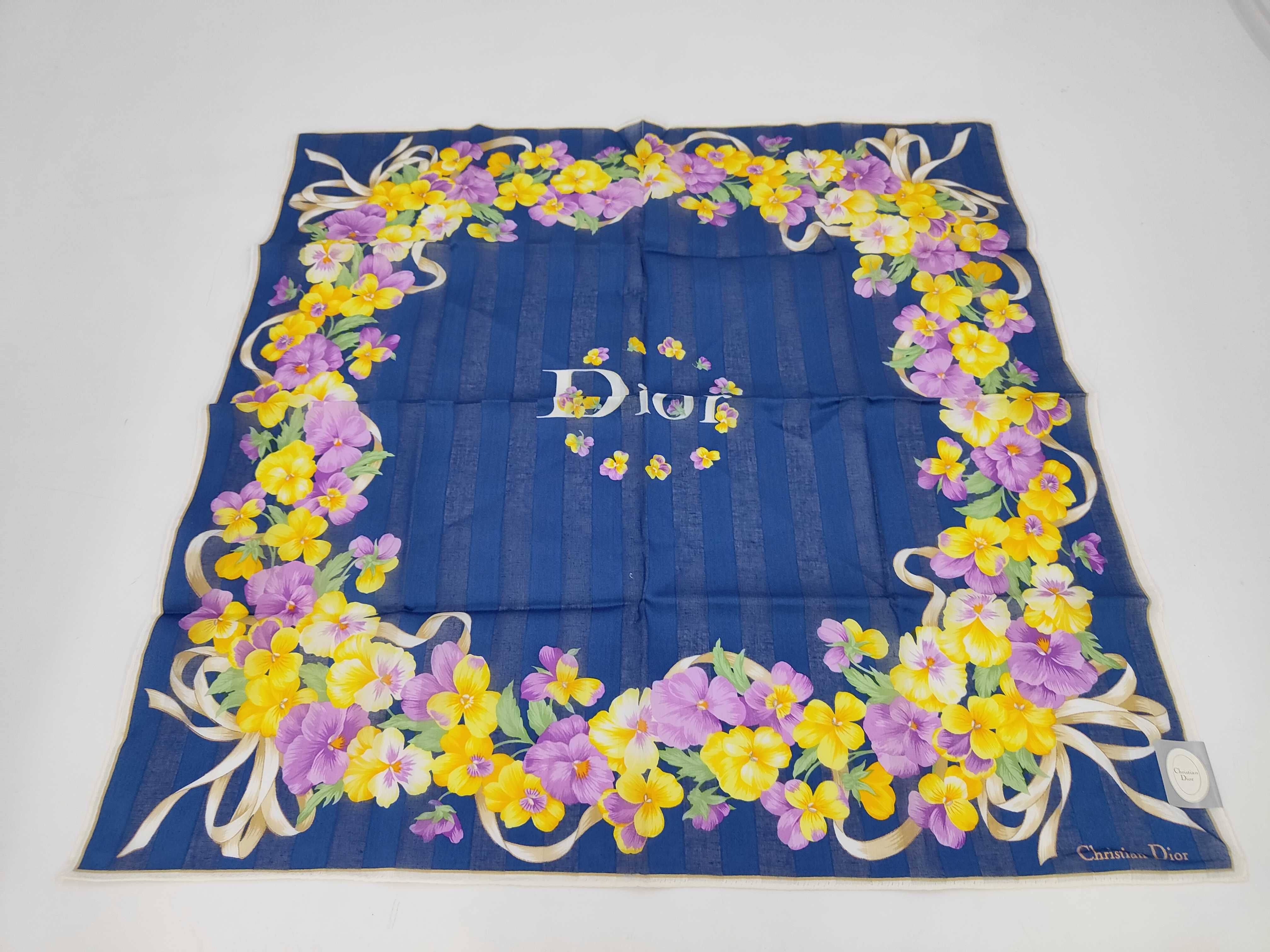 handkerchief scarf with sticker, logo, floral pattern, ribbon, navy, and other accessories.