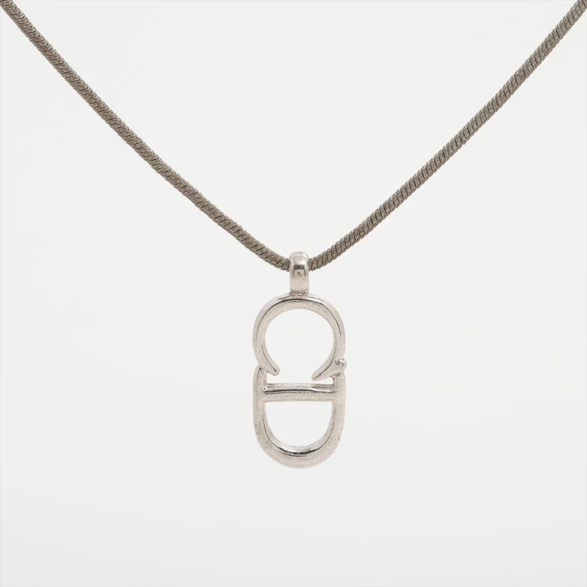 CD logo necklace, metal, silver. Shows signs of wear including dents, — view 2