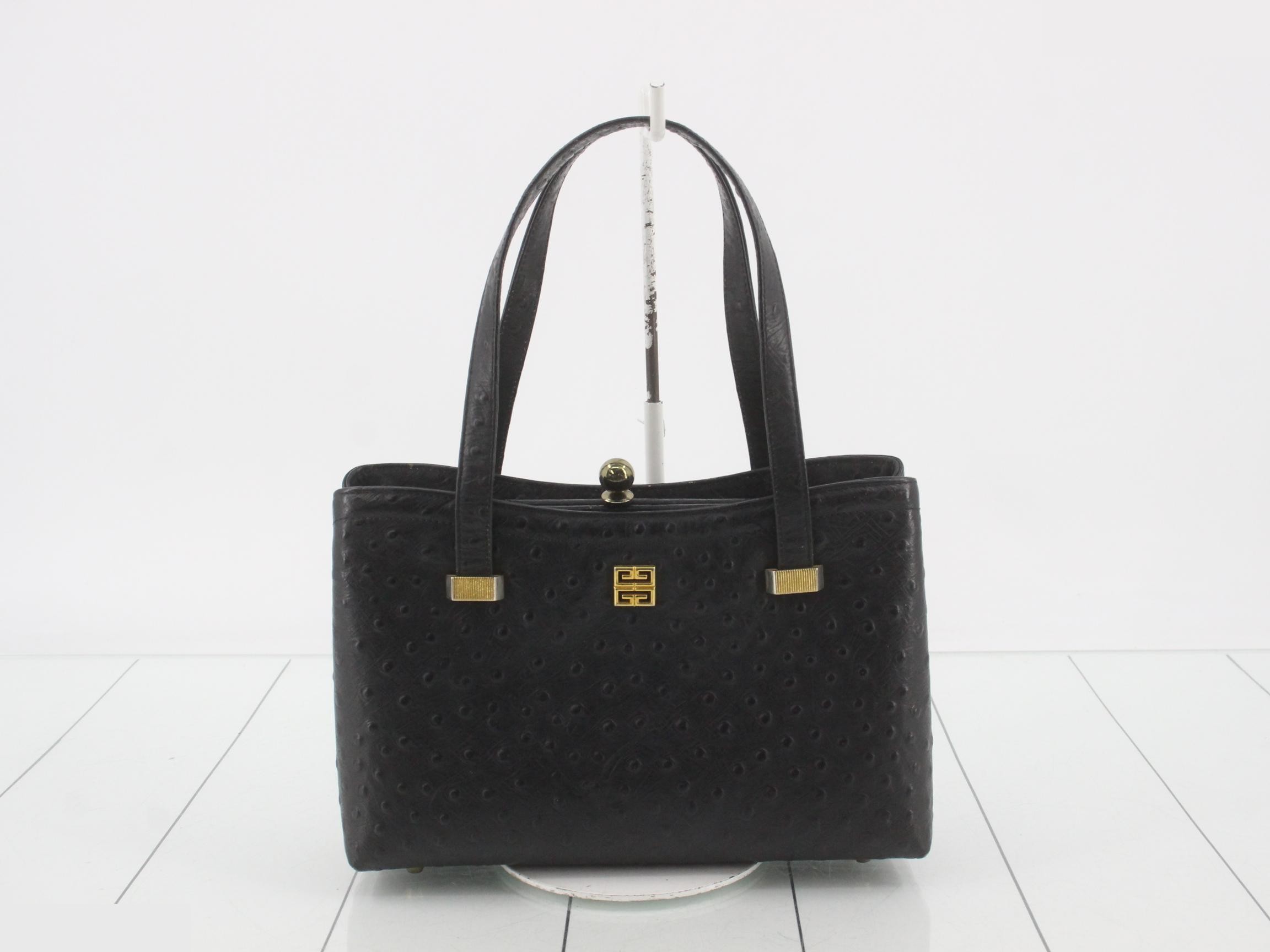 Black ostrich leather handbag with clasp closure.