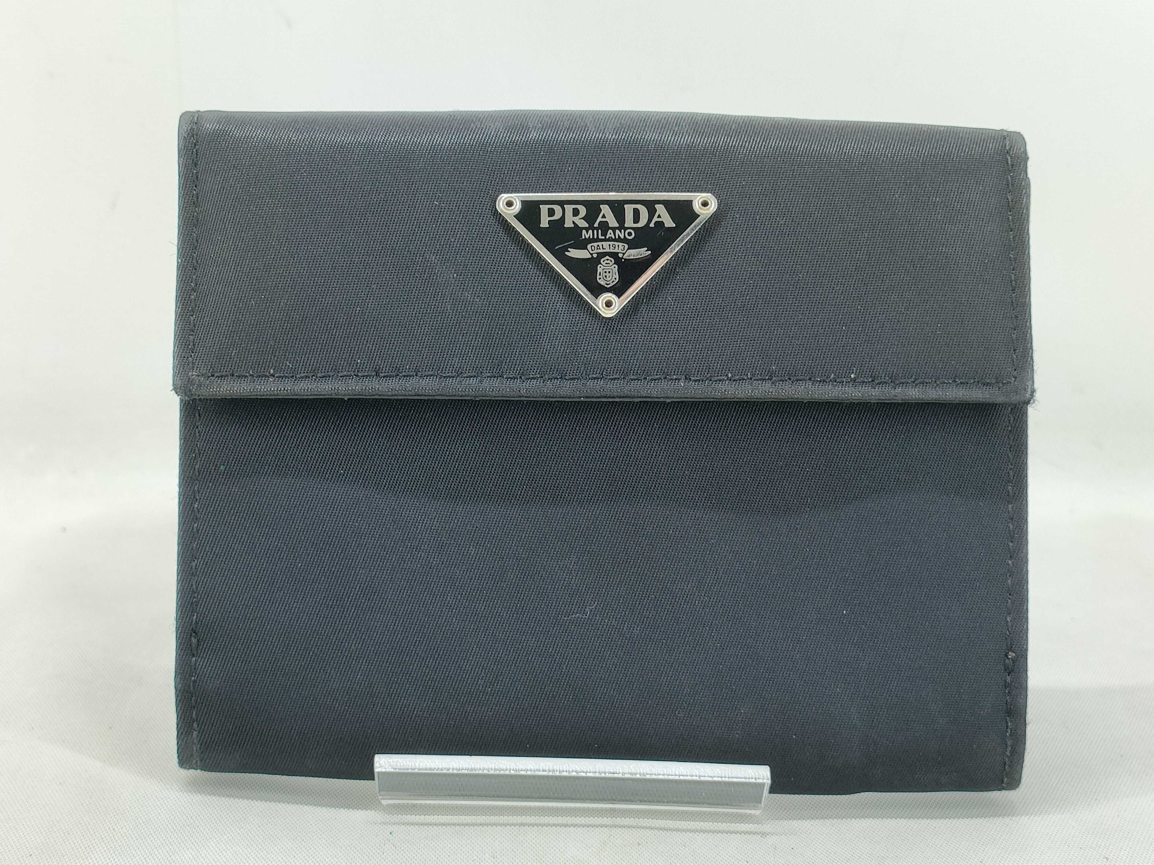 nylon bifold wallet with triangular logo hardware.