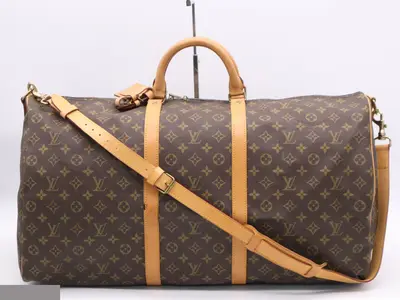 Keepall Bandoulière 60 with shoulder strap, name tag, and handle.