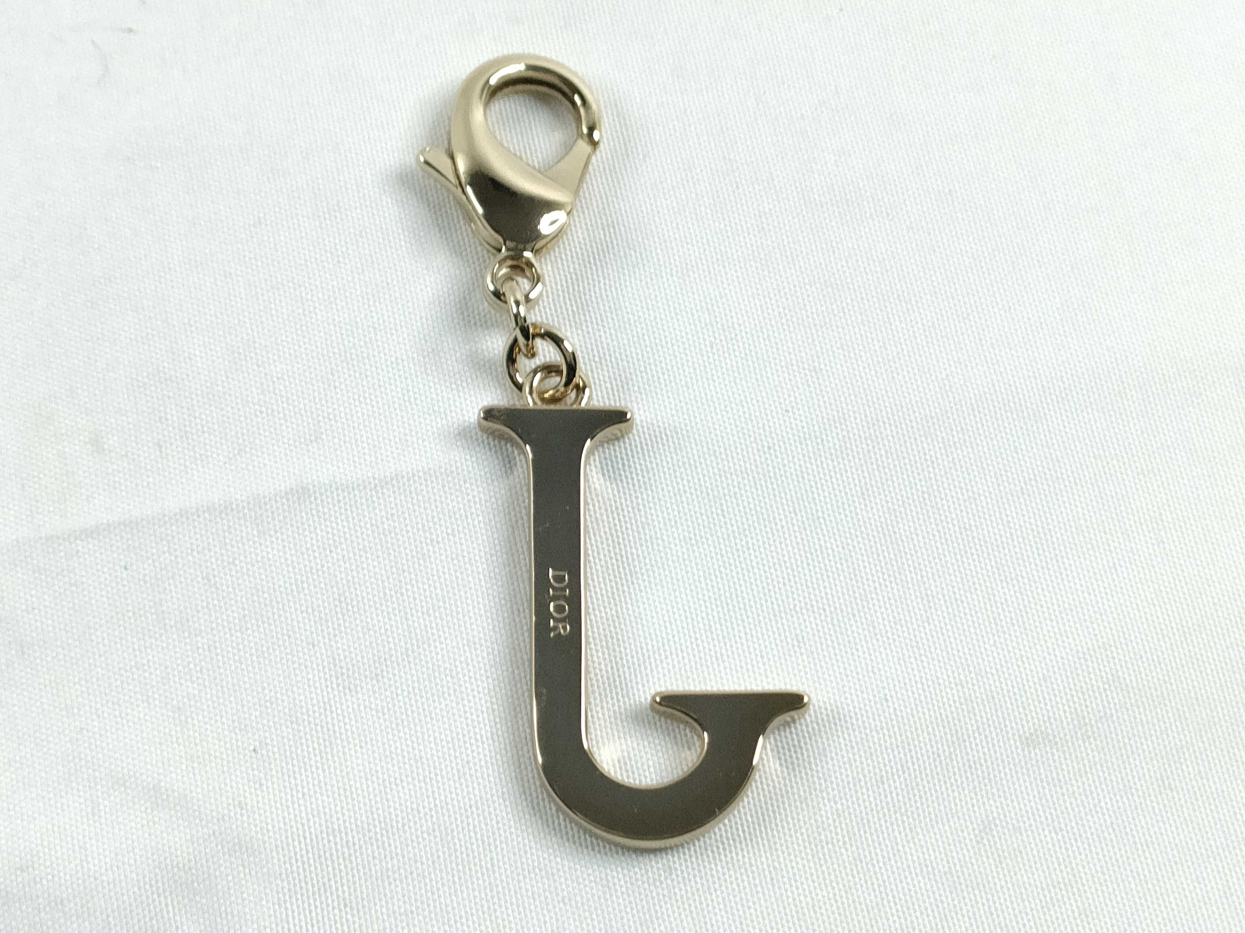 Roman alphabet charm, "J," with tag. — view 2