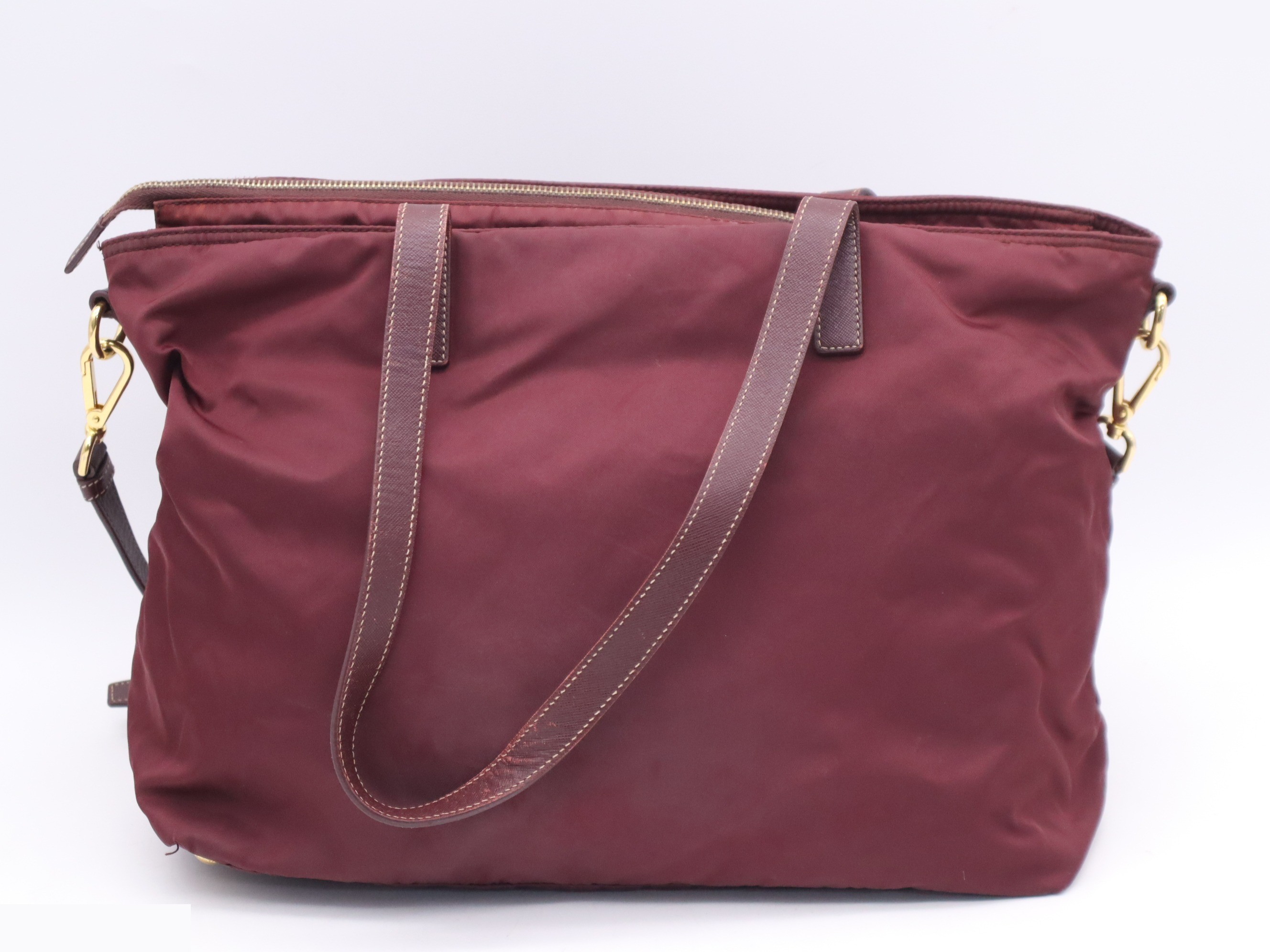 Nylon tote bag with triangular logo, red, gold hardware, and shoulder strap. — view 2