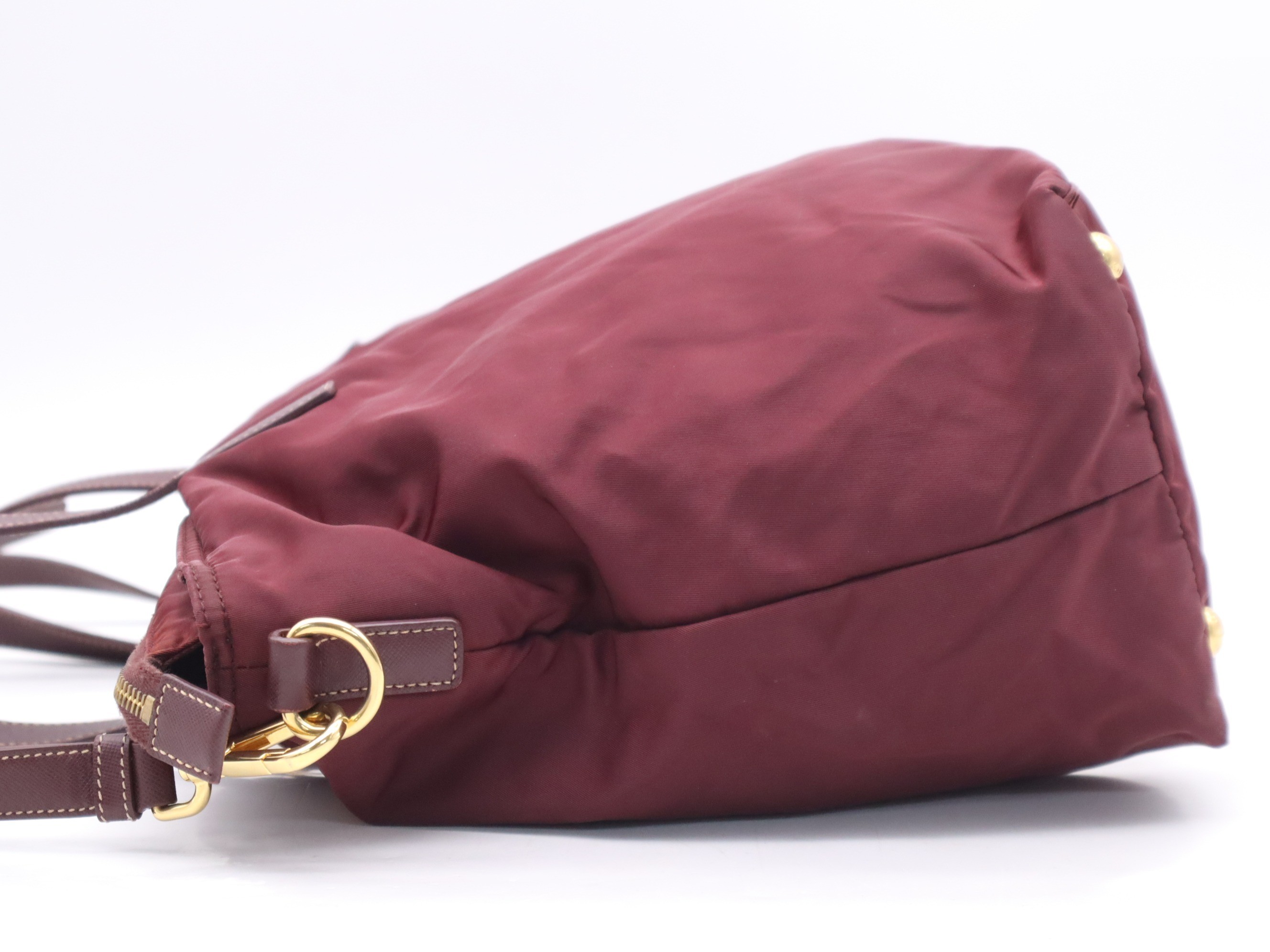 Nylon tote bag with triangular logo, red, gold hardware, and shoulder strap. — view 3