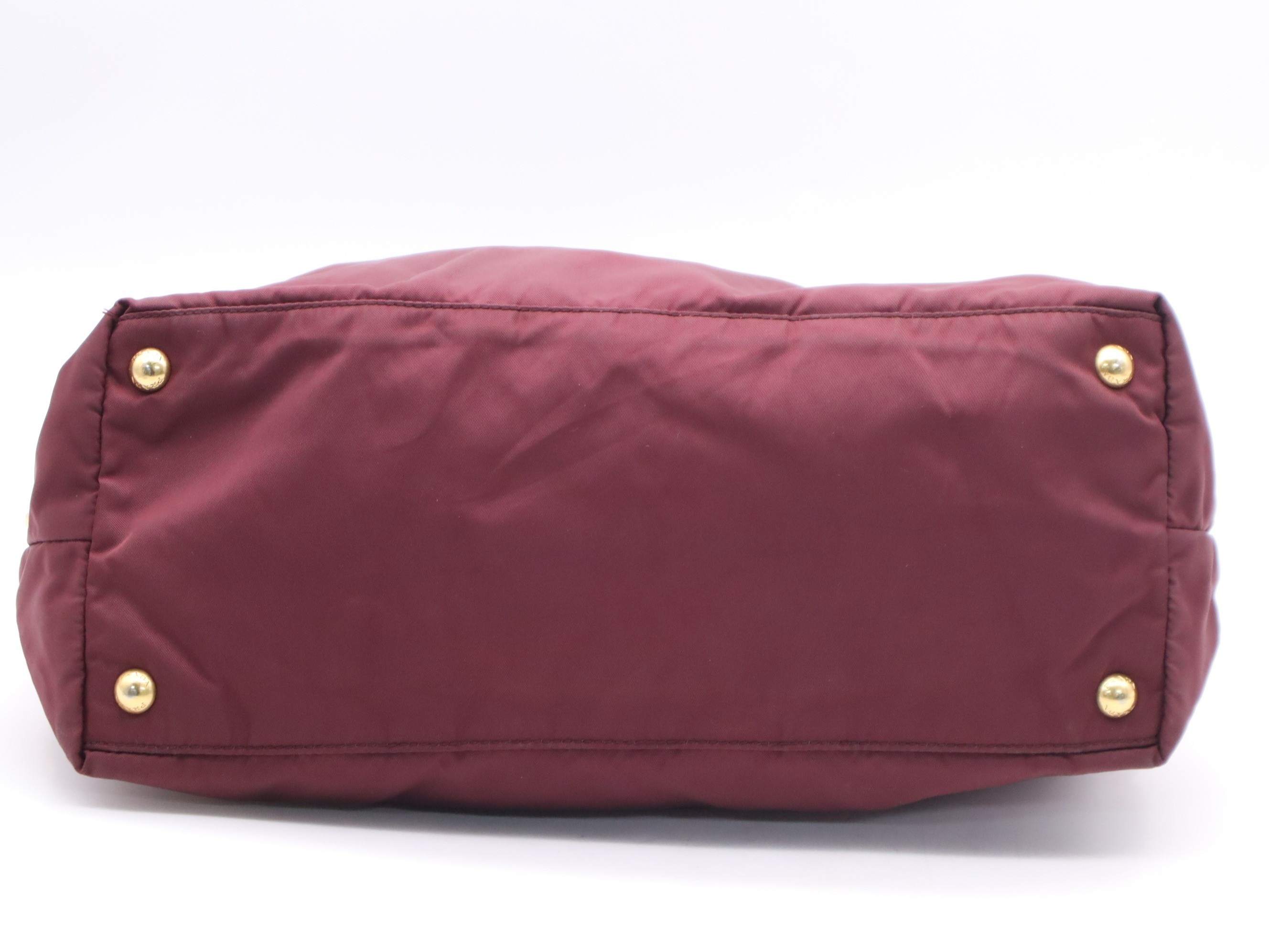 Nylon tote bag with triangular logo, red, gold hardware, and shoulder strap. — view 4