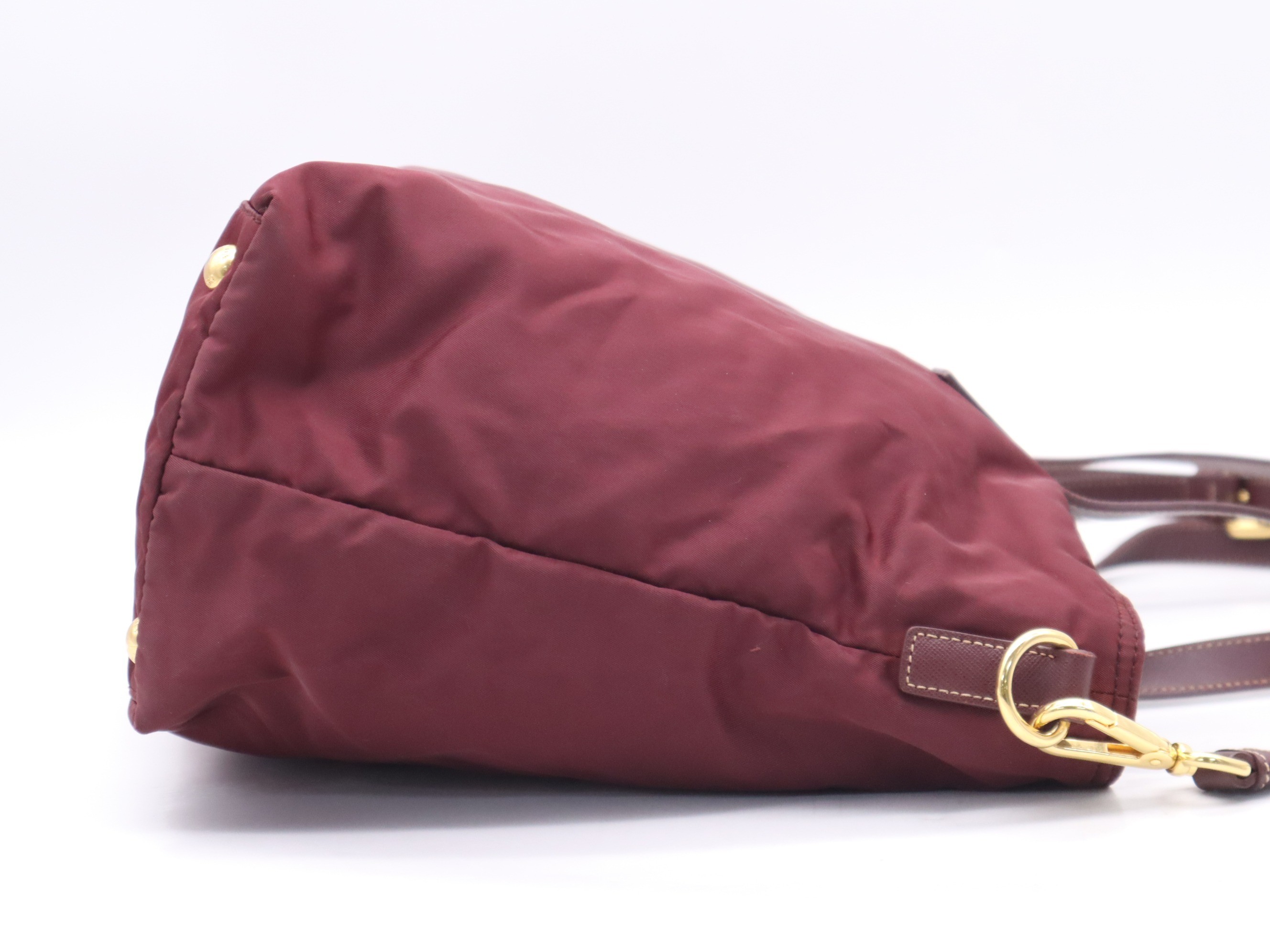 Nylon tote bag with triangular logo, red, gold hardware, and shoulder strap. — view 5