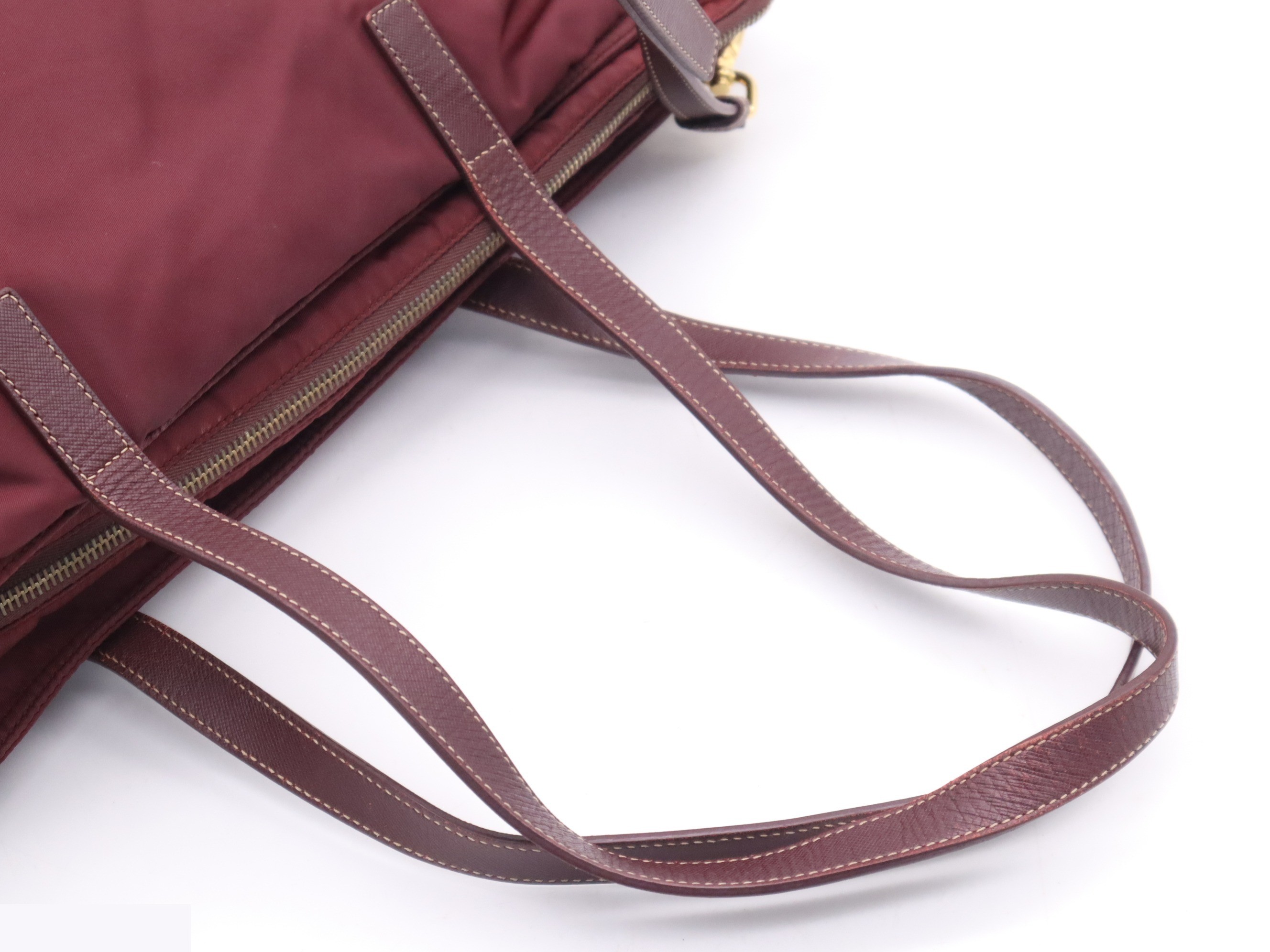 Nylon tote bag with triangular logo, red, gold hardware, and shoulder strap. — view 6