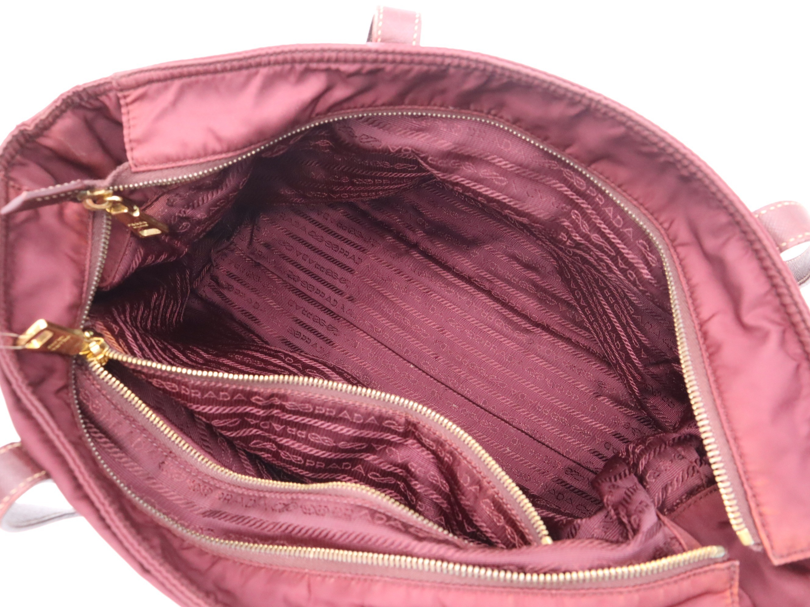 Nylon tote bag with triangular logo, red, gold hardware, and shoulder strap. — view 7