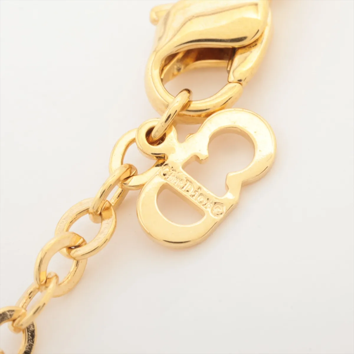 logo necklace, gold plated with rhinestones. Shows wear, tarnishing, and stains. — view 4