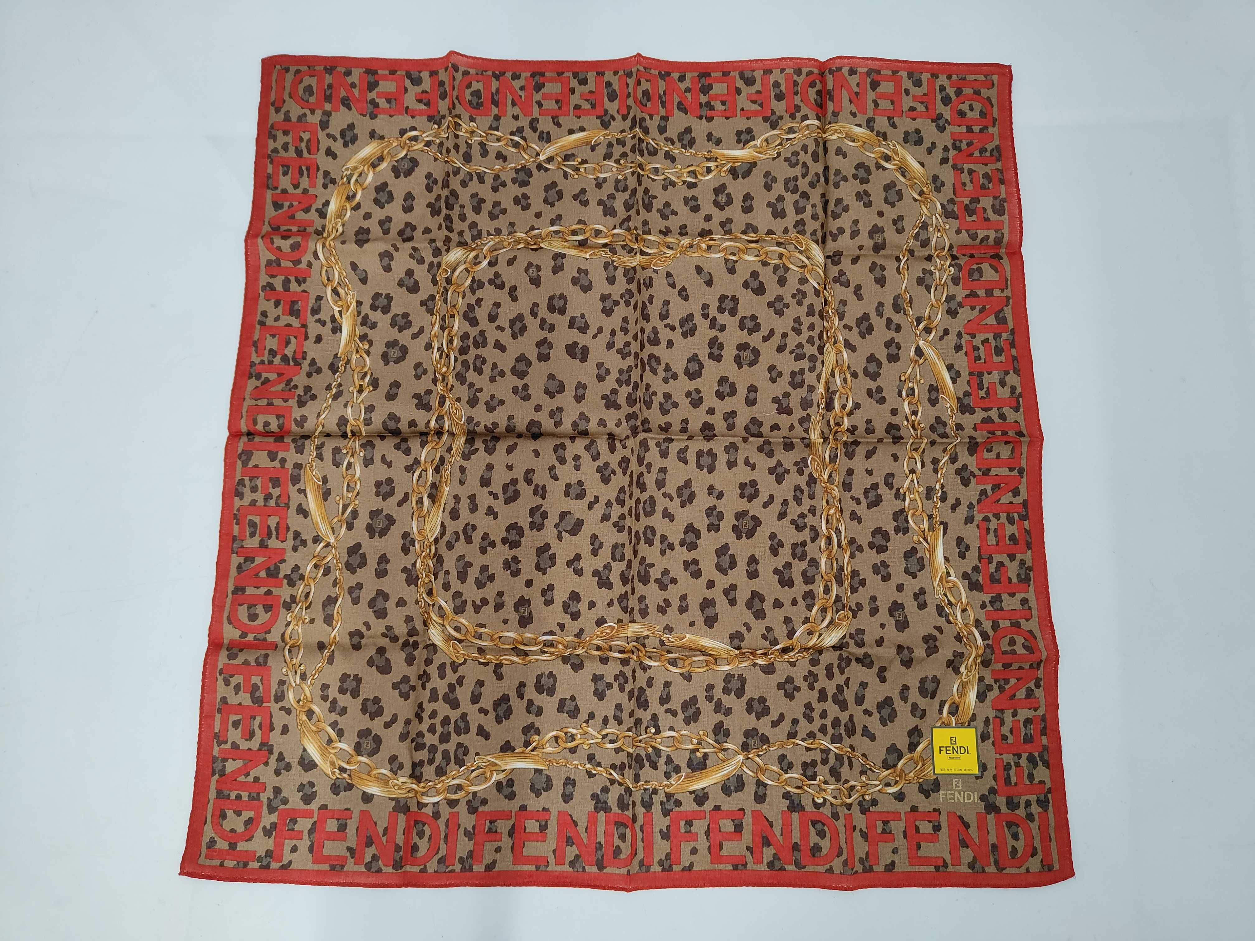 handkerchief scarf with sticker, logo border, leopard print, chain, and other accessories.