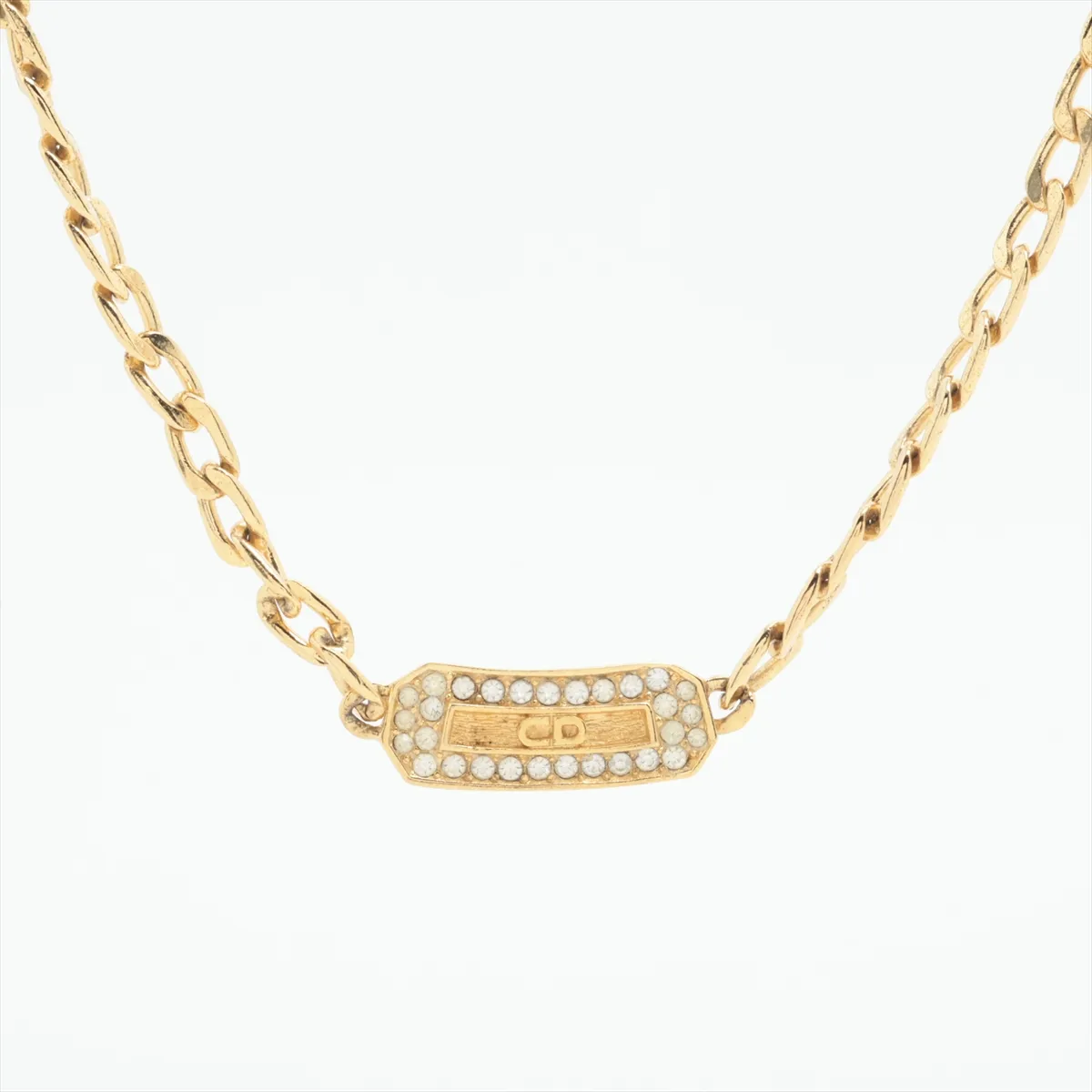CD logo necklace, gold plated with rhinestones. Shows signs of wear,