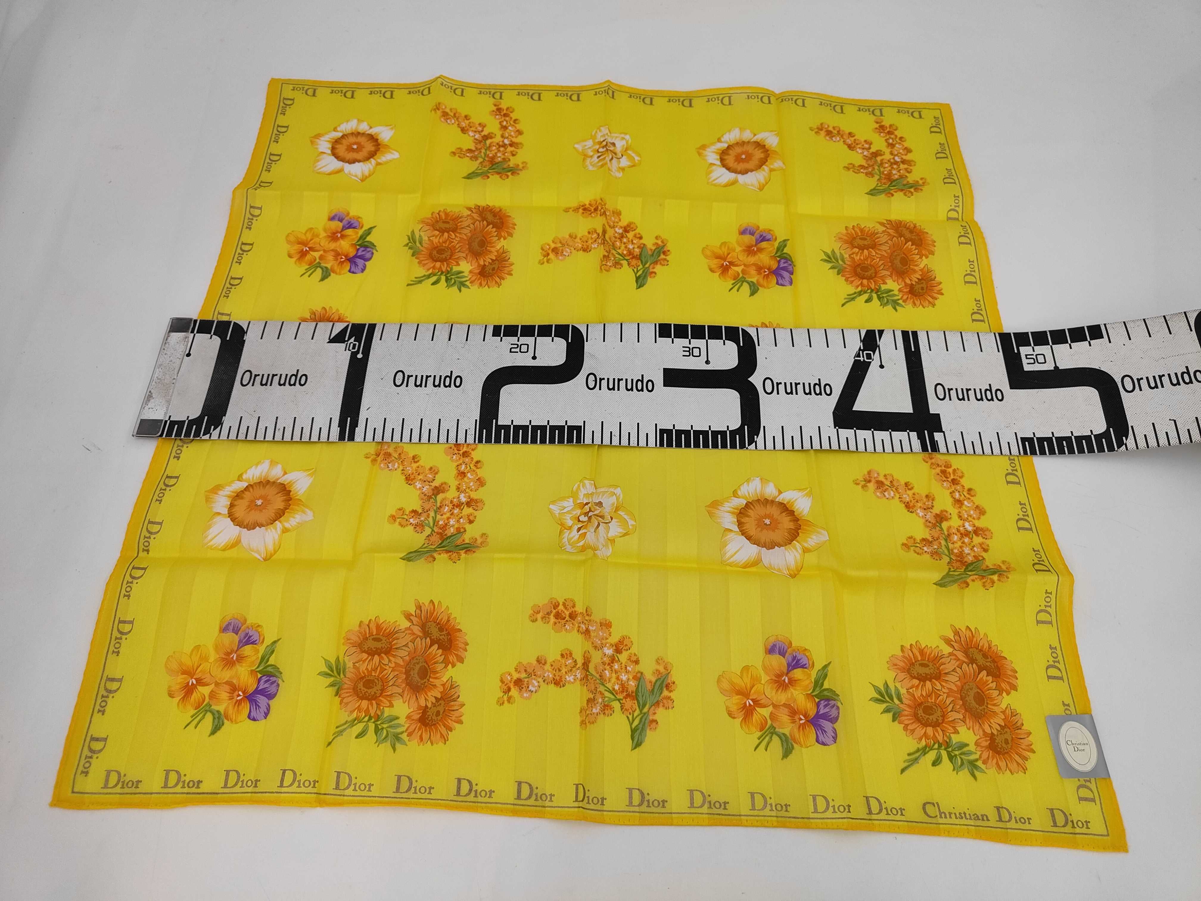 handkerchief scarf with sticker, border logo, floral pattern, orange, and other accessories. — view 2