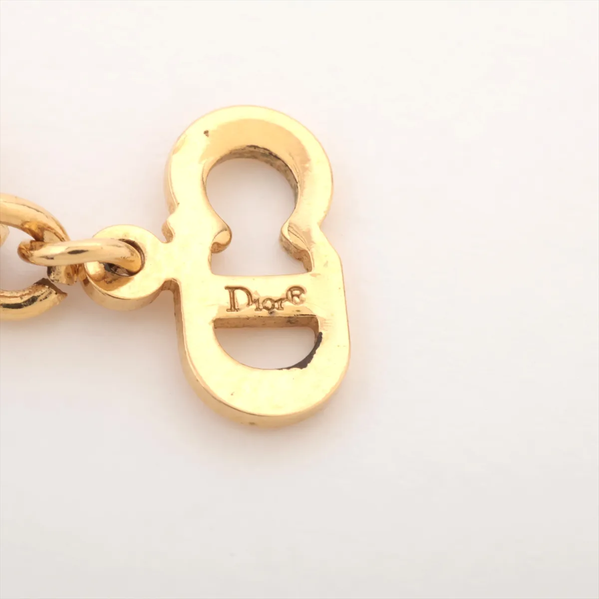 CD logo necklace, gold plated with rhinestones. Shows signs of wear, including — view 4