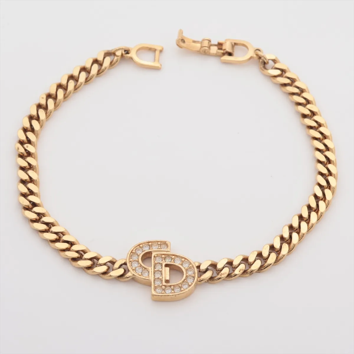 CD logo bracelet, gold plated with rhinestones. Shows signs of wear, including