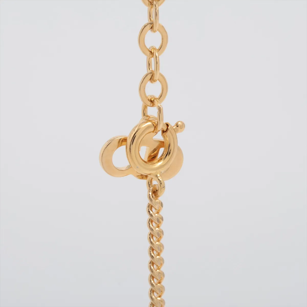 CD logo necklace, gold-plated with rhinestones. Shows wear, tarnishing, and stains. — view 3