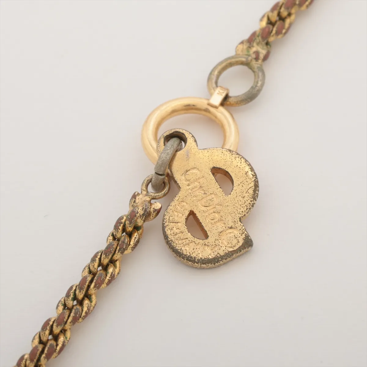 teardrop necklace, gold plated with colored stones, gold and green. Shows signs of wear, including — view 4