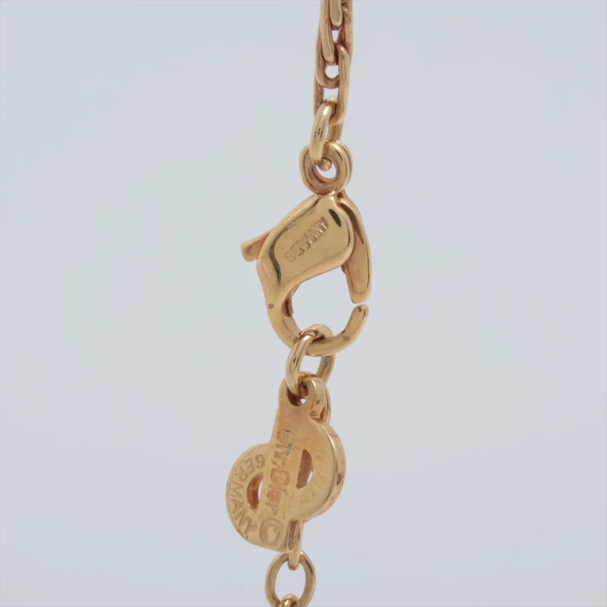 logo necklace, gold plated with rhinestones, black and gold. Shows signs of wear, including — view 3