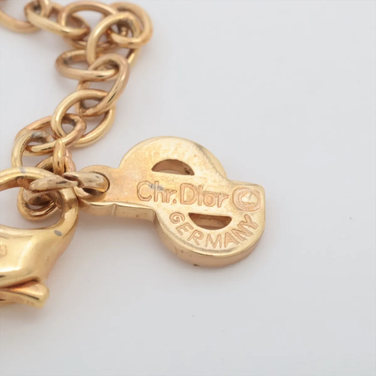 logo necklace, gold plated with rhinestones, black and gold. Shows signs of wear, including — view 4