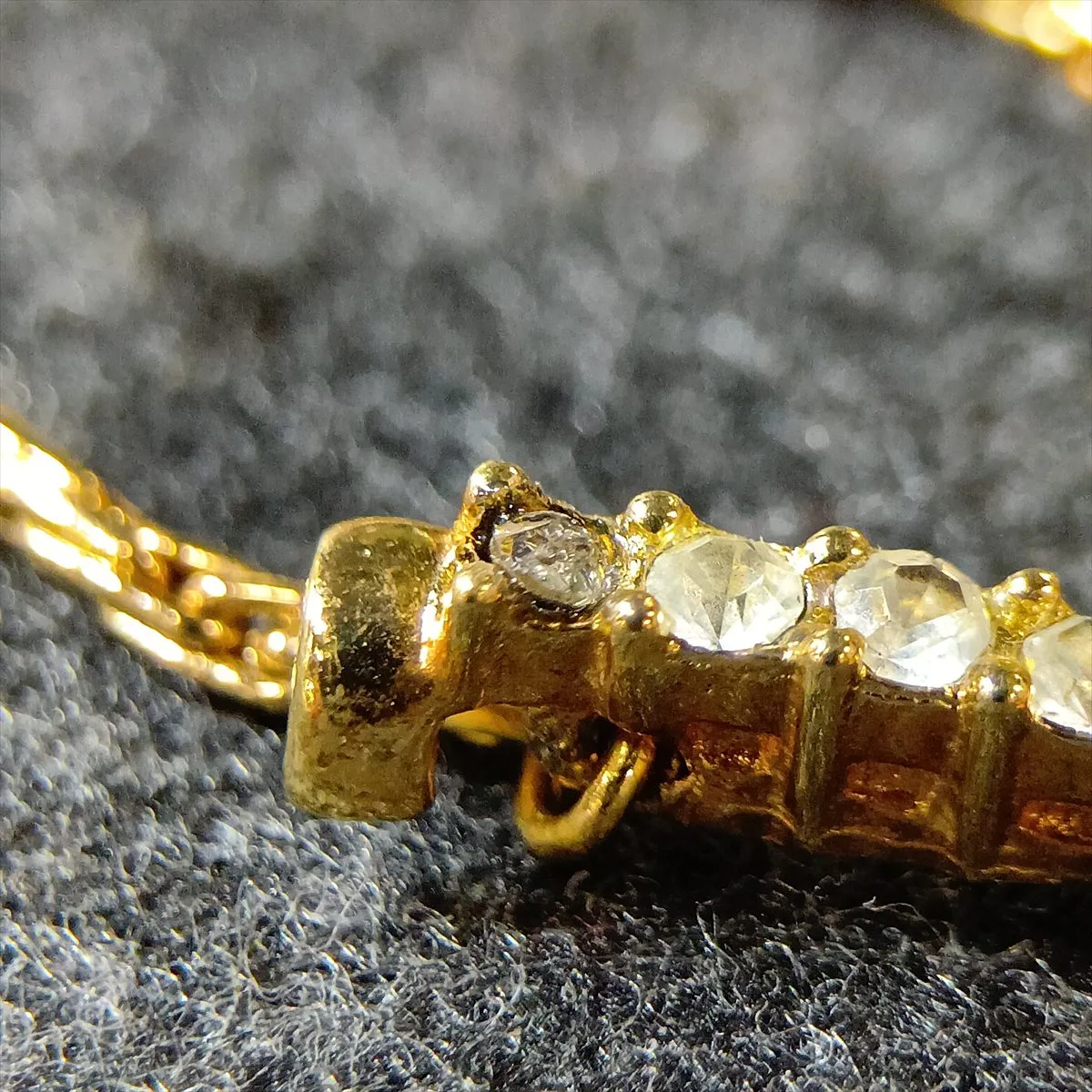logo necklace, gold plated with rhinestones, black and gold. Shows signs of wear, including — view 6