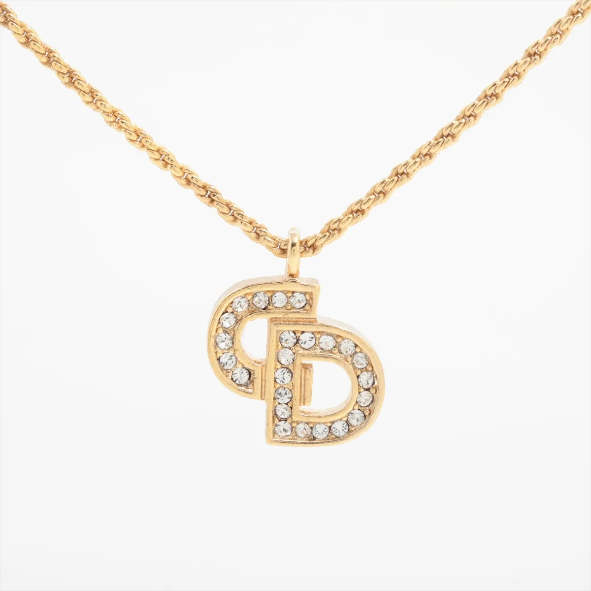 CD logo necklace, gold plated with rhinestones. Shows