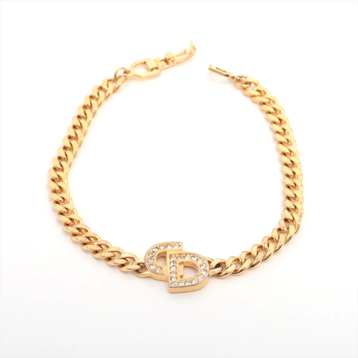 CD logo bracelet, gold plated with rhinestones. Shows signs of wear, including